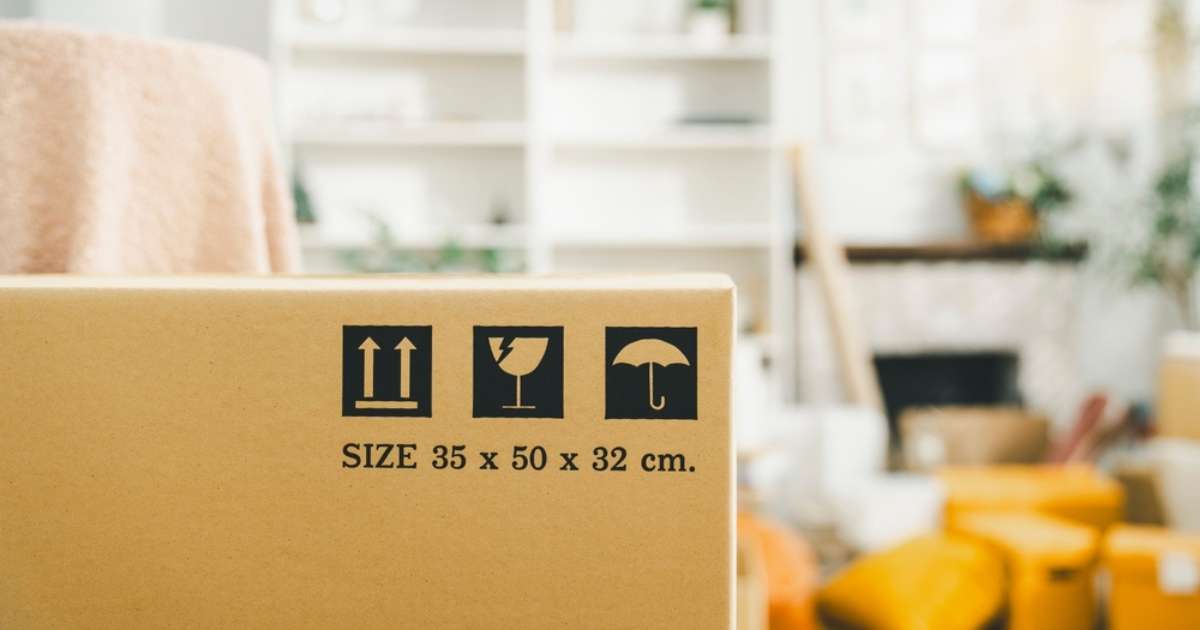 A moving box with items to be packed in the background