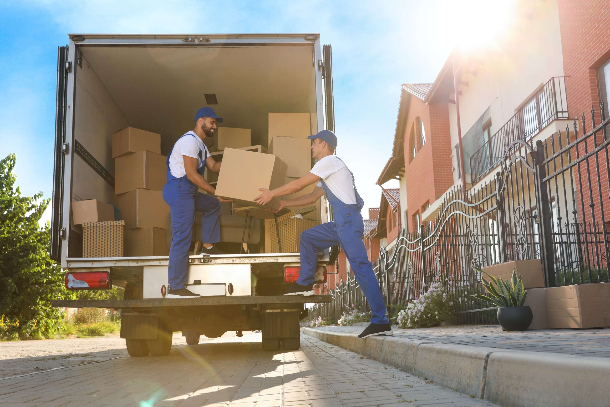 Seville movers carrying boxes from the back of a moving truck 