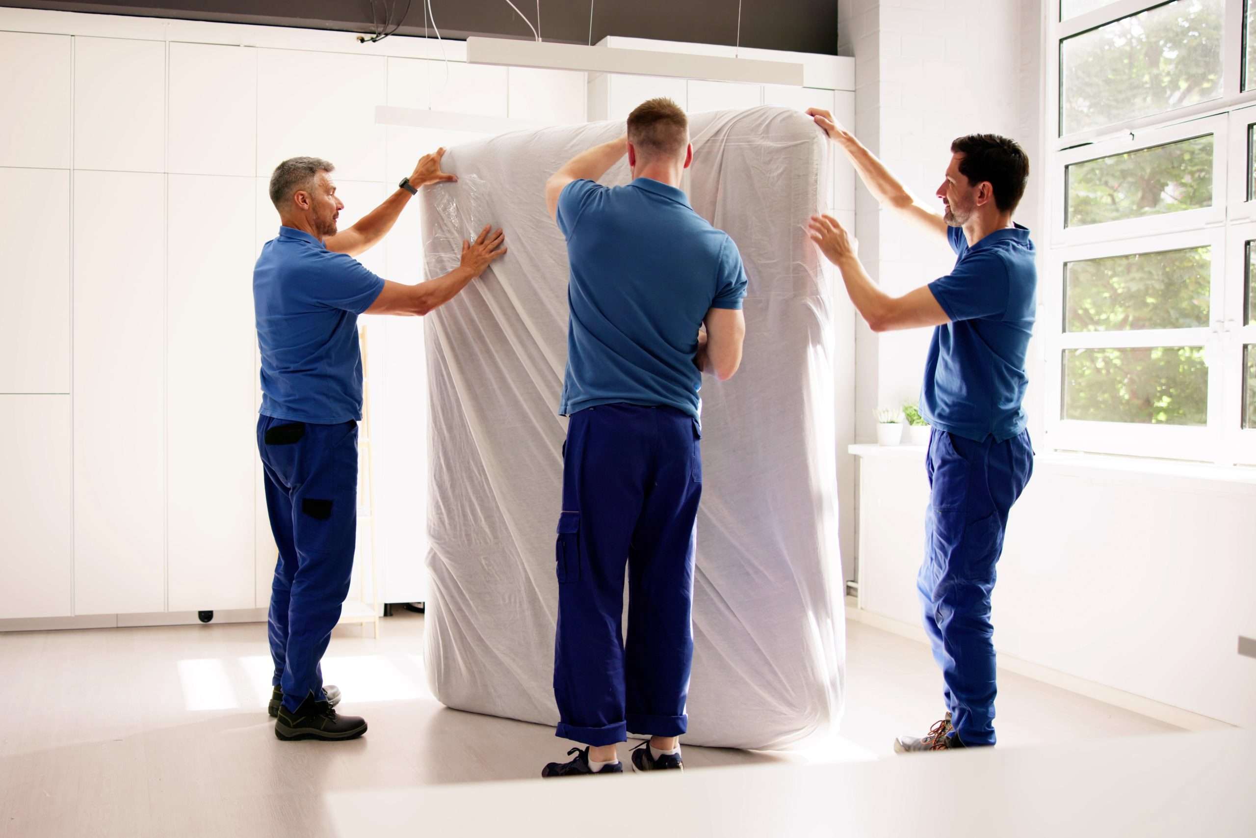 Seville movers wrapping a mattress for transport 