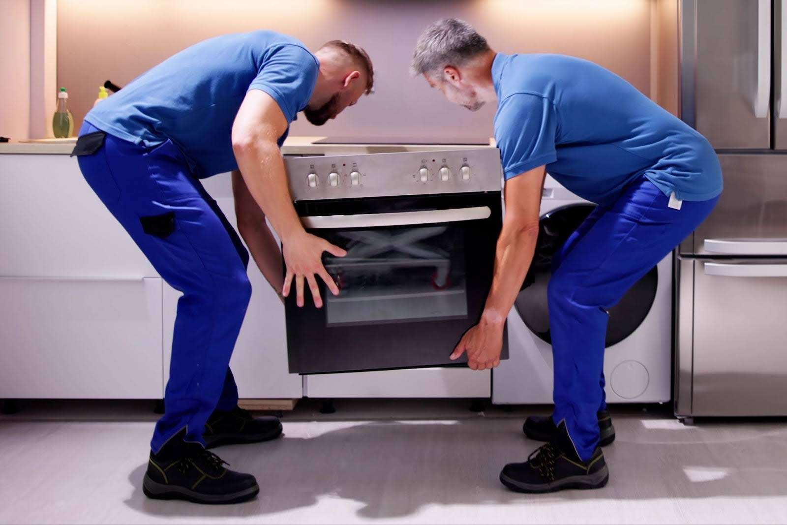 Two Elyria Ohio movers carefully removing oven from kitchen