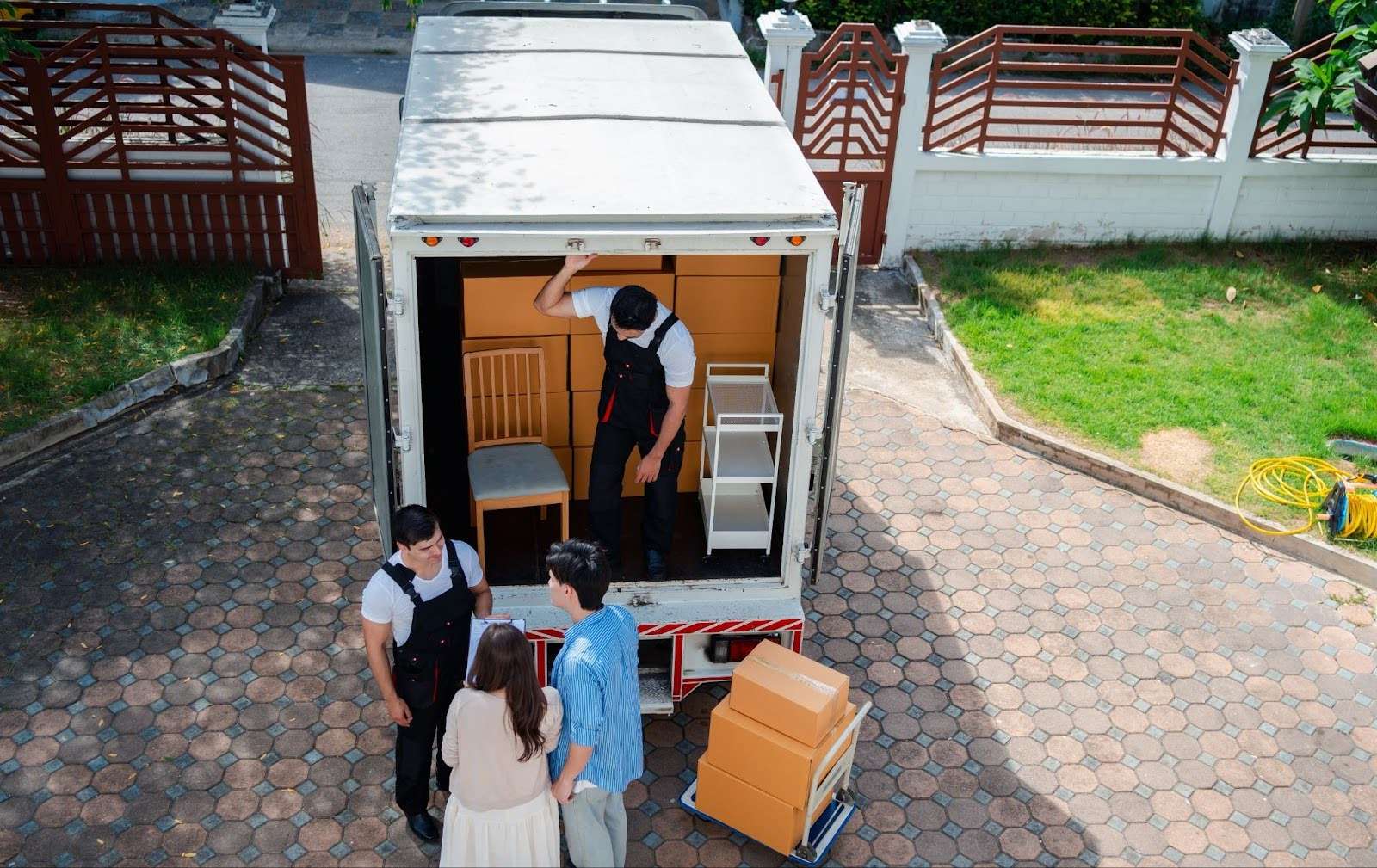 Aerial shot of two Alliance Ohio movers along with young homeowners standing outside of a moving truck